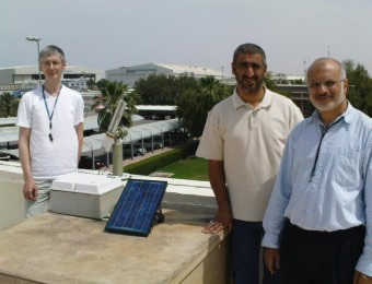 (left to right) Jozef Ulanowski, Eshaq Husain and Ismail Sabbah with the photometer (airport in background).