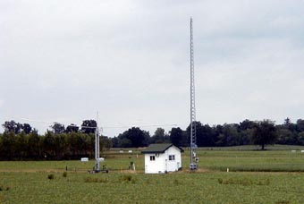 A view of the instrument from the southwest. It is conveniently situated near an equipment shed. To the left is a mobile remote sensing tower; to the right, an antenna tower that also supports the photometer.
