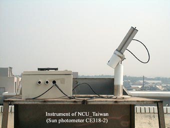 A close-up view of the NCU sun photometer on the roof of a four-story building.
